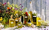Kräuterölflaschen mit Etiketten & Korb mit blühenden Kräutern