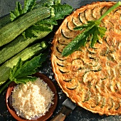 Courgette quiche and bowl of grated cheese