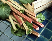 Several sticks of rhubarb beside a crate