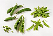 Pea pods and mangetouts, some opened with peas