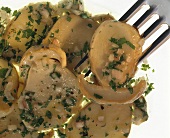 Mushroom salad with onions & parsley (close-up with fork)