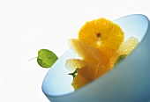 Grapefruit and orange dessert with mint in blue bowl