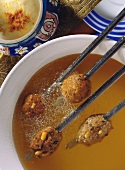 Mince fondue on sticks in hot oil; cinnamon yoghurt