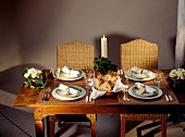 Laid table with plates, napkins and burning candle