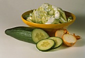 Cucumber salad with onions, dill & cream dressing in bowl