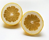Two pomelo halves (cross section) on white background