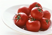 Several tomatoes on a white plate