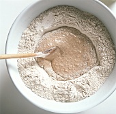 Making sourdough: mixing the sourdough starter with flour