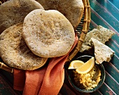 Arabic flat bread in bread basket, spread, tumbler