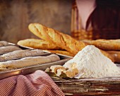 Still life with flour, yeast & baguettes (baked, unbaked)