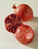 Two pomegranate halves in front of a pomegranate