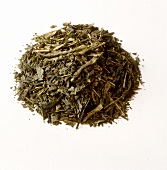Grüner Tee (getrocknete Teeblätter) auf weißem Untergrund