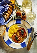 Saltimbocca with risotto on blue & white plate; bread, wine