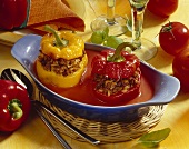 Stuffed peppers with tomatoes in a bowl; basil