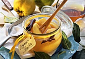 Quinces in Cognac in open jar, surrounded by ingredients