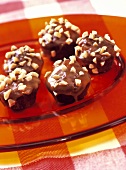 Snickers muffins with chopped peanuts on glass plate