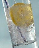 A Glass of Water with Lemon Slice and Straw