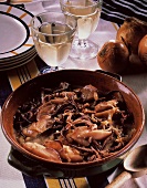 Cuttlefish ragout with onions in ceramic pot; white wine