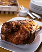Roast leg of lamb with rosemary on a white platter