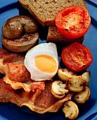 Fried egg, bacon, mushrooms & tomatoes with bread