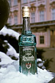 Eine Flasche Absinth im Schnee