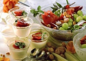 Panna cotta in small bowls, fruit salad and amaretti