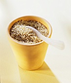 Sesame seeds in a clay pot with a spoon