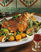 Easter roast lamb with artichokes and potatoes on a platter