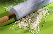Crushing rice noodles with a rolling pin