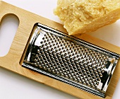 A piece of parmesan with hand grater