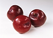 Three plums on white background