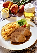 Roast pork with beer sauce, chips, mustard and beer
