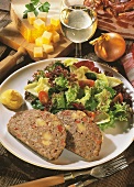 Cheese meatloaf with mixed salad leaves on plate