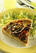 A piece of vegetable quiche with lettuce on plate