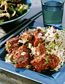 Spicy spare ribs with rice on a shallow blue plate