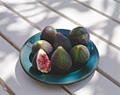 Whole figs and one fig half on blue plate