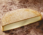 Französischer Käse Abondance auf braunem Untergrund