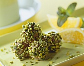 Pistachio and orange pralines on a light green tray