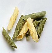 Yellow and green penne on a white background