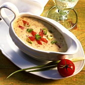 Mustard sauce with tomatoes and spring onions in sauce-boat