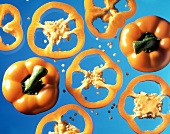 Yellow peppers and pepper rings on blue background