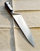Kitchen knife on a light-coloured table cloth