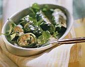 Stuffed chard parcels (one cut open) in a gratin dish