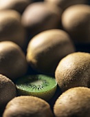 Half a kiwi fruit between whole kiwis