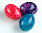 Three coloured eggs on a light background