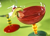 Strawberry and raspberry smoothie in glass with fruit kebab