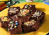 Squares of chocolate cake, decorated with sweets