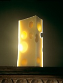 A piece of Emmentaler cheese, backlit