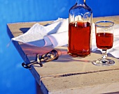 Rotwein in Glas und Flasche auf Holztisch mit Korkenzieher