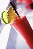 Strawberry juice with pineapple and lime in a glass
